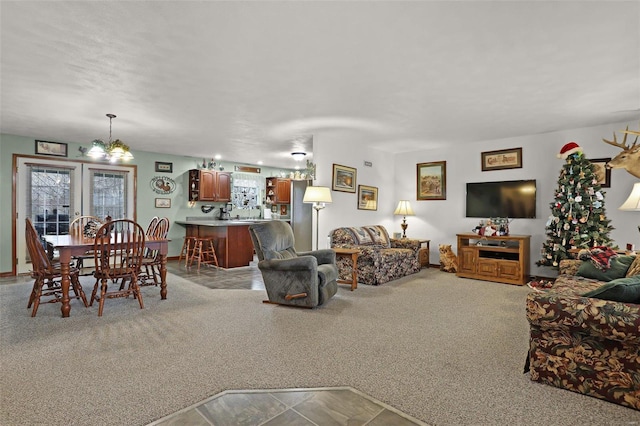 carpeted living room featuring a chandelier