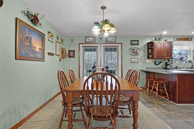 dining space with an inviting chandelier, plenty of natural light, and sink