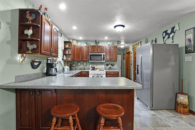 kitchen with a kitchen bar, kitchen peninsula, sink, and appliances with stainless steel finishes