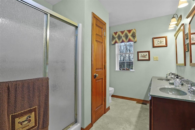 bathroom featuring tile patterned floors, vanity, an enclosed shower, and toilet