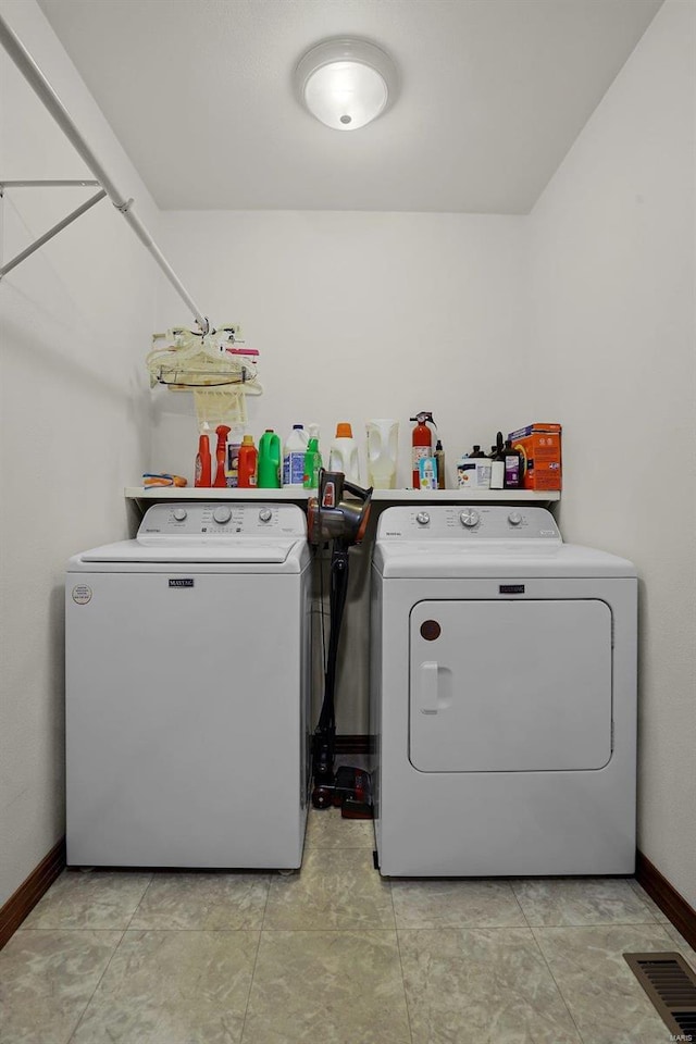 clothes washing area featuring washer and dryer and light tile patterned floors