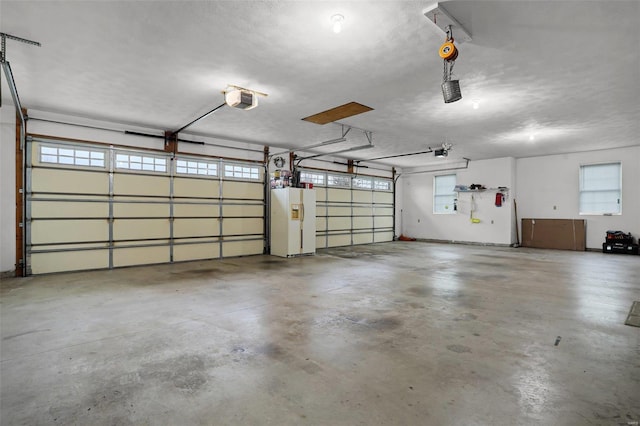 garage with white refrigerator with ice dispenser and a garage door opener