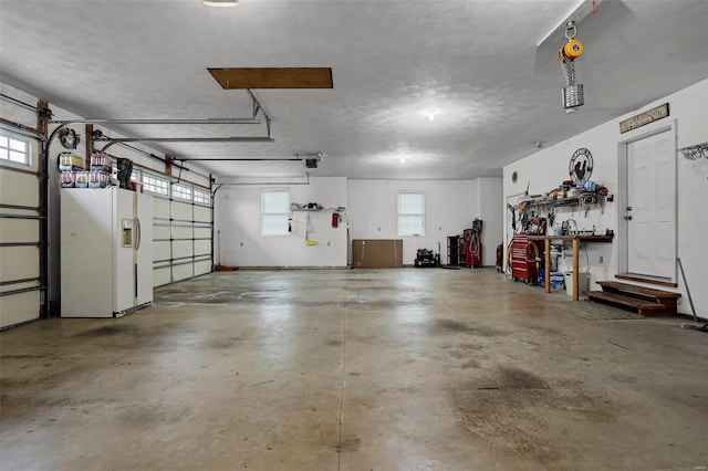 garage featuring white refrigerator with ice dispenser and a garage door opener