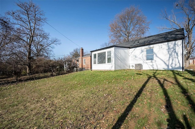 rear view of house with a yard and central AC