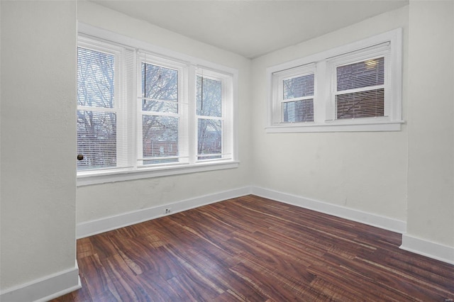 unfurnished room featuring dark hardwood / wood-style flooring and a wealth of natural light