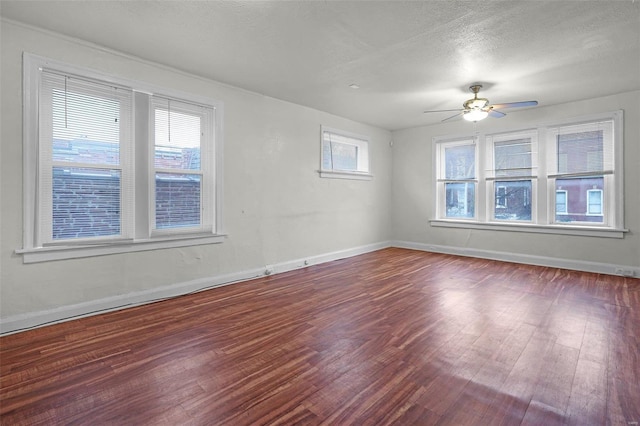 unfurnished room with a textured ceiling, dark hardwood / wood-style floors, and ceiling fan