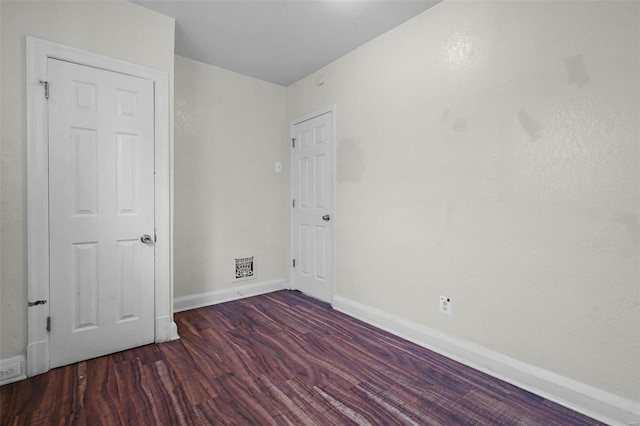 unfurnished room with dark hardwood / wood-style flooring