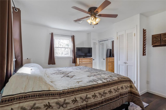 bedroom featuring dark wood finished floors, visible vents, a ceiling fan, and baseboards