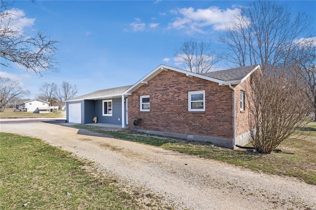 view of front of property featuring a garage, brick siding, driveway, and roof with shingles