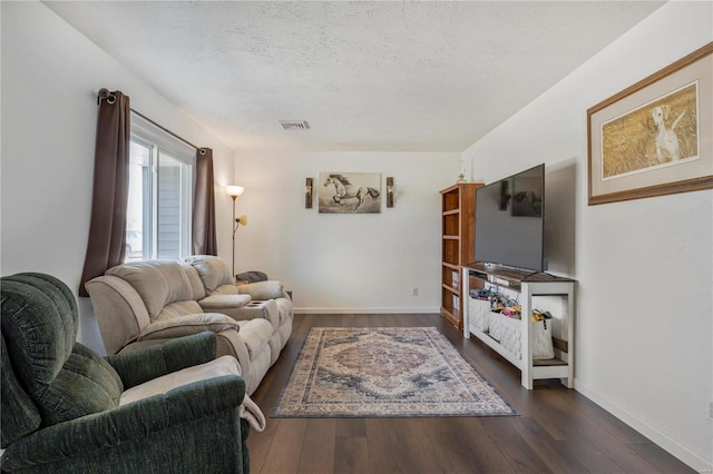 living room with visible vents, baseboards, a textured ceiling, and dark wood finished floors