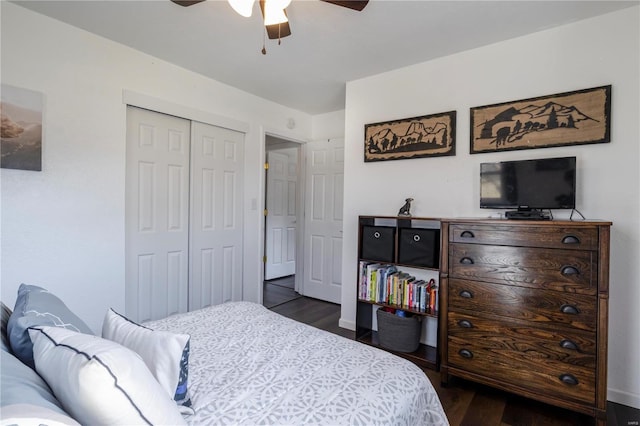 bedroom with dark wood-style floors, baseboards, a ceiling fan, and a closet