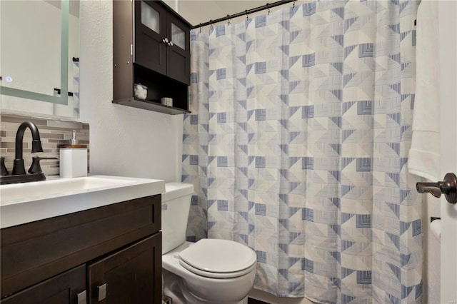 bathroom with decorative backsplash, curtained shower, toilet, and vanity