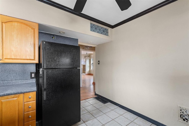 kitchen with crown molding, black refrigerator, light tile patterned floors, and ceiling fan