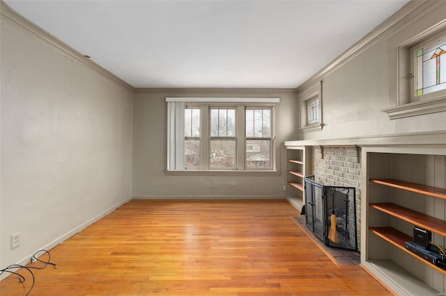 unfurnished living room featuring crown molding, light wood-type flooring, and a fireplace