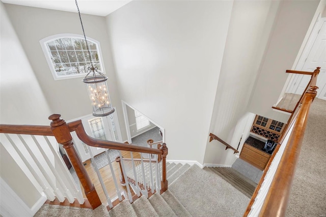 stairs featuring carpet flooring and a chandelier