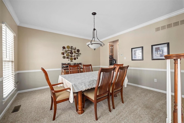 carpeted dining space featuring ornamental molding