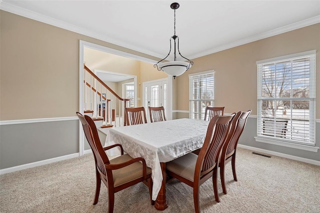 carpeted dining area featuring crown molding