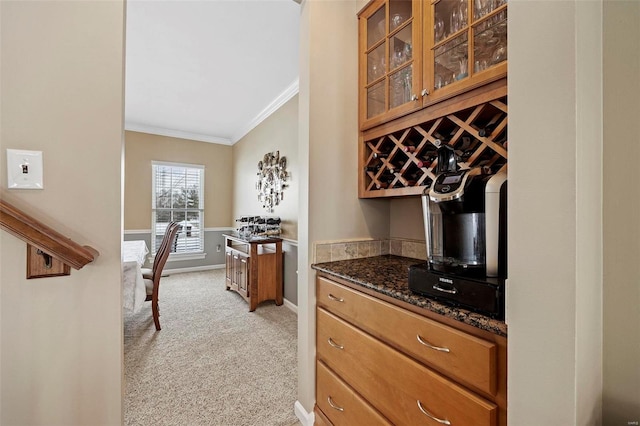 interior space with light carpet, dark stone counters, and ornamental molding