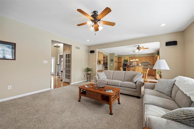 carpeted living room featuring ceiling fan