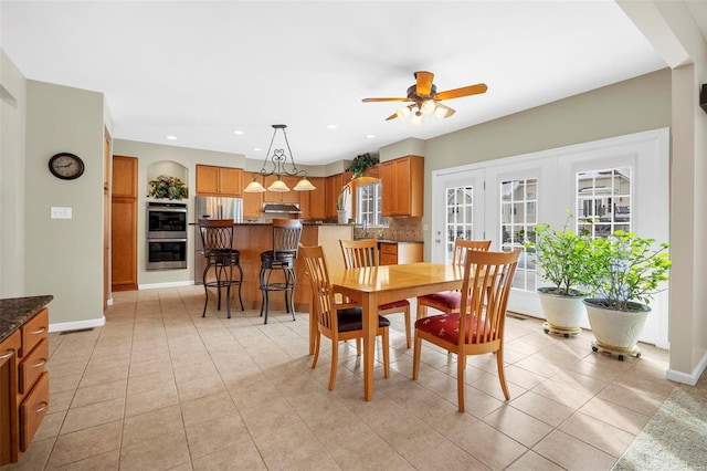 dining room featuring ceiling fan, light tile patterned floors, and sink