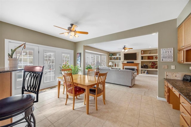 tiled dining area with ceiling fan and built in features