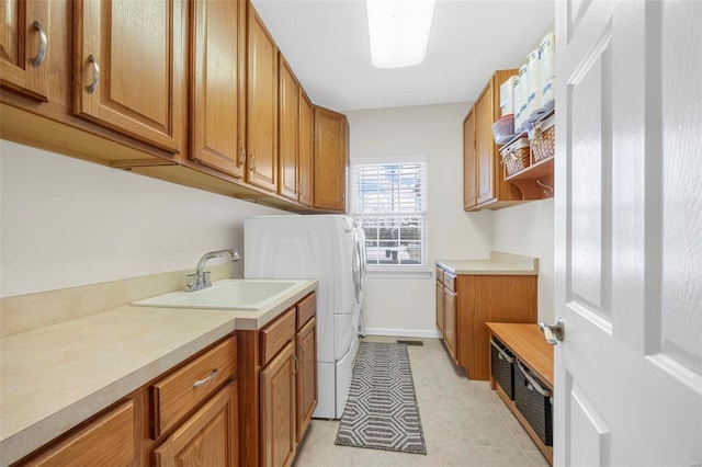 washroom featuring light tile patterned flooring, cabinets, sink, and washing machine and clothes dryer