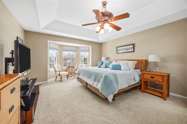 bedroom featuring carpet, ceiling fan, and a tray ceiling