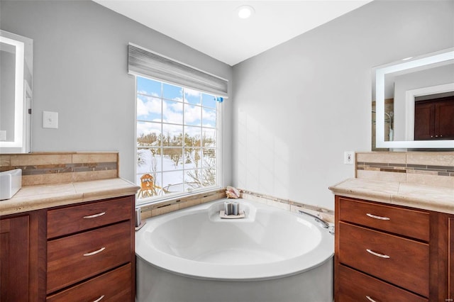 bathroom featuring a bathing tub, vanity, and backsplash