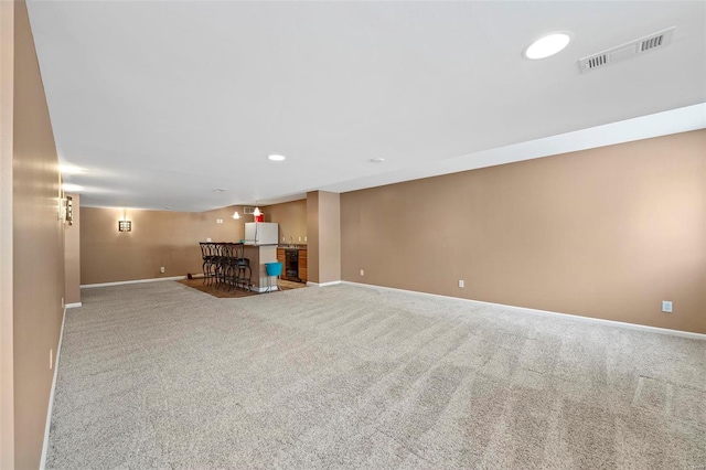 basement with carpet floors and white fridge