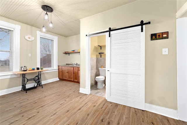 bathroom with a healthy amount of sunlight, toilet, wood-type flooring, and sink