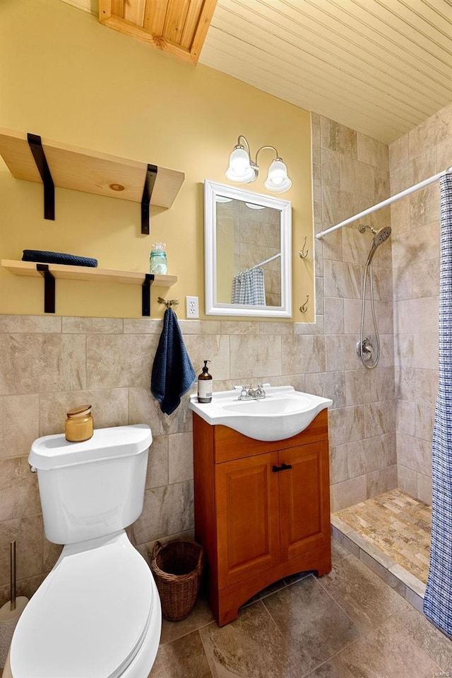 bathroom with tile patterned flooring, toilet, vanity, tile walls, and a shower with shower curtain