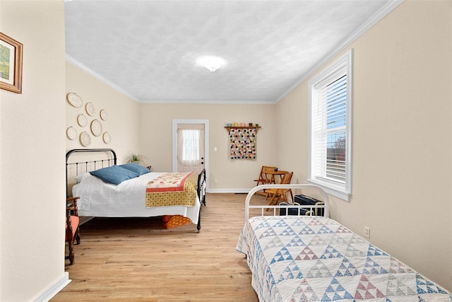 bedroom with light wood-type flooring, ornamental molding, and multiple windows