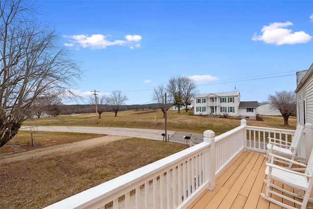 wooden terrace featuring covered porch and a yard