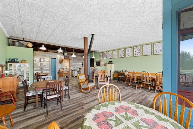 dining area with wood-type flooring and a textured ceiling