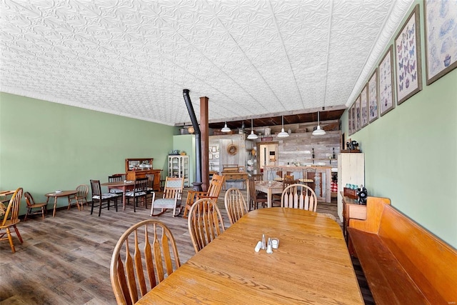 dining room featuring wood walls, hardwood / wood-style floors, and a textured ceiling