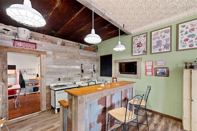 kitchen featuring butcher block countertops, wooden walls, wood-type flooring, and decorative light fixtures