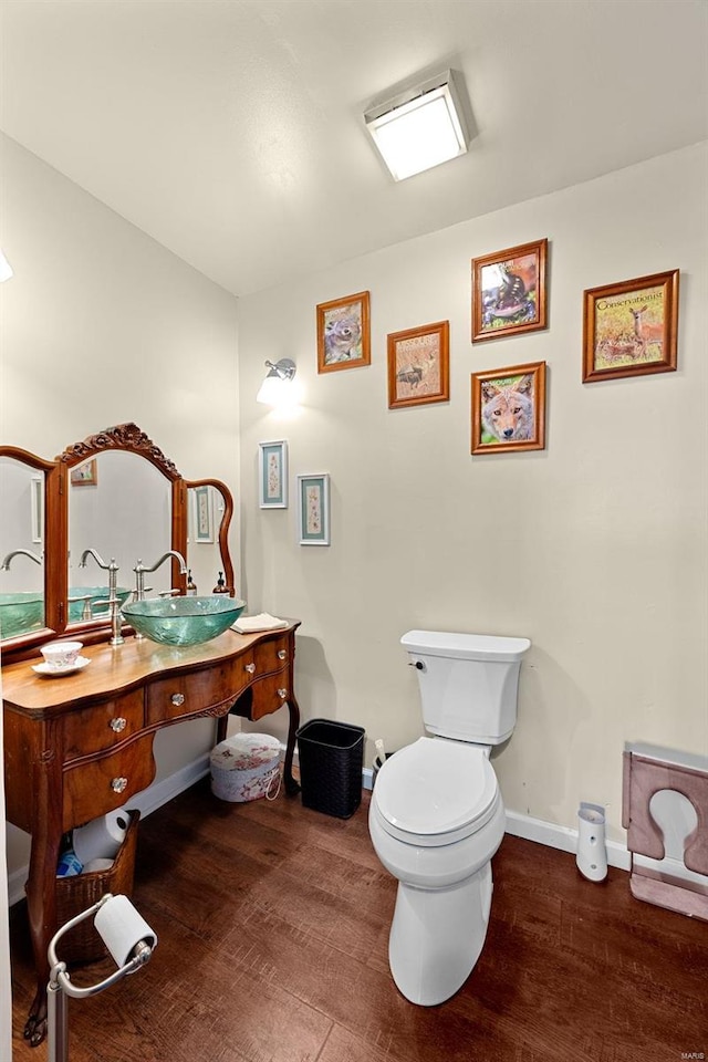 bathroom with hardwood / wood-style flooring, vanity, and toilet