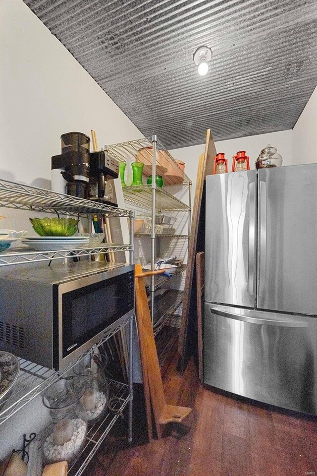 kitchen with stainless steel fridge and dark hardwood / wood-style floors