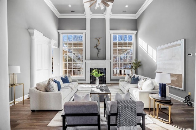 living room featuring ornamental molding, a wealth of natural light, and a tile fireplace