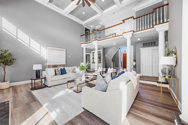 living room featuring a high ceiling, wood-type flooring, beamed ceiling, decorative columns, and coffered ceiling