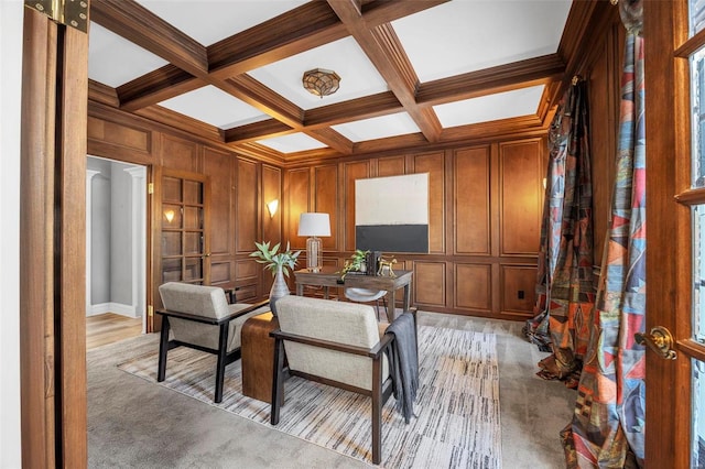 sitting room featuring coffered ceiling, light colored carpet, and beamed ceiling