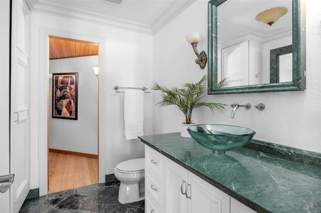 bathroom with vanity, toilet, and ornamental molding