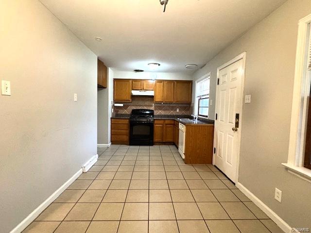 kitchen with black range, light tile patterned flooring, dishwasher, and backsplash