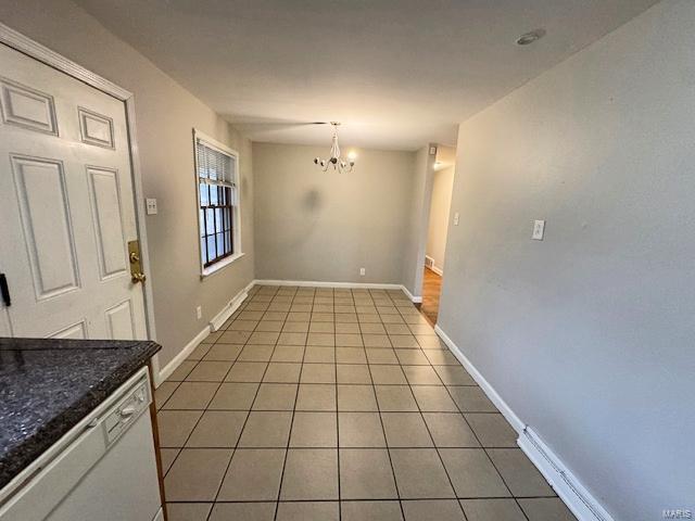 unfurnished dining area with light tile patterned floors and an inviting chandelier