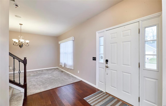 foyer featuring dark hardwood / wood-style flooring, a wealth of natural light, and an inviting chandelier