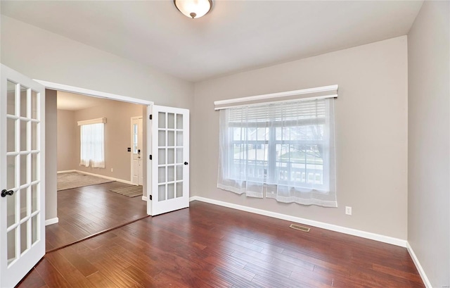 empty room with french doors and dark wood-type flooring