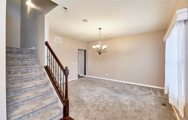 stairs with carpet flooring and a chandelier