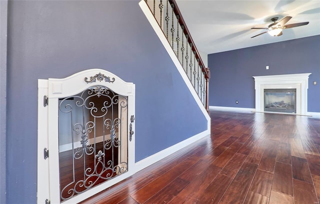 stairway with hardwood / wood-style flooring and ceiling fan