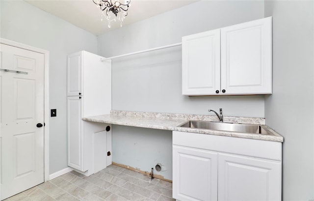 washroom featuring sink and a notable chandelier