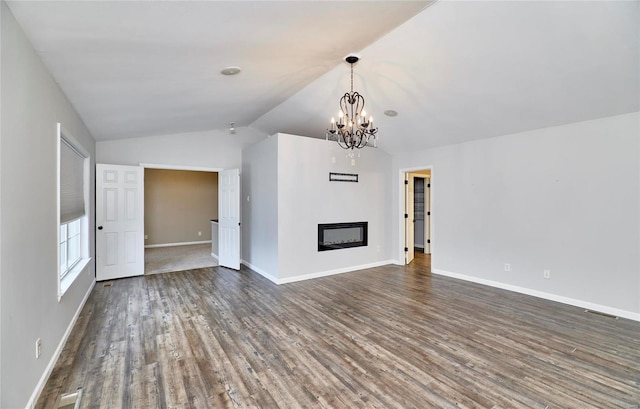 unfurnished living room featuring dark wood-type flooring, lofted ceiling, and a notable chandelier